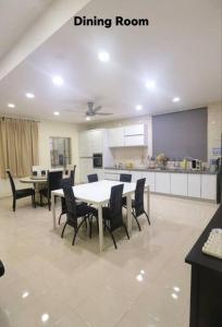 a dining room with a table and chairs and a kitchen at Big House In Alor Setar Taman Sri Ampang in Alor Setar