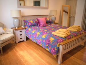 a bedroom with a bed with a colorful comforter at The Manor Coach House in Chilham