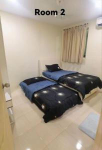 two beds in a bedroom with at Big House In Alor Setar Taman Sri Ampang in Alor Setar