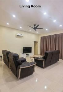 ein Wohnzimmer mit 2 Stühlen und einem Flachbild-TV in der Unterkunft Big House In Alor Setar Taman Sri Ampang in Alor Setar