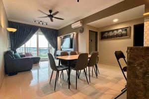 a living room with a dining room table and chairs at COZY Modern Spacious 8pax S PICE Penang in Bayan Lepas