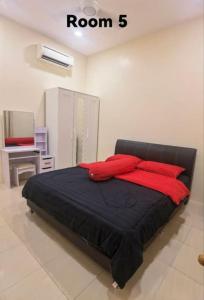 a bedroom with a black bed with red pillows at Big House In Alor Setar Taman Sri Ampang in Alor Setar