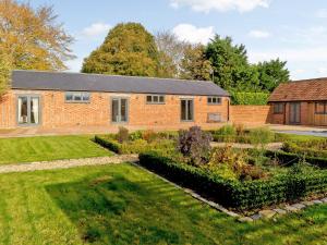 a brick house with a garden in front of it at Bluebell Barn - Uk12792 in Royal Wootton Bassett