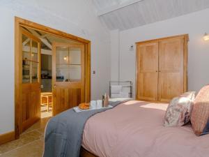 a bedroom with a bed and a wooden cabinet at Buttercup Barn - Uk12963 in Royal Wootton Bassett