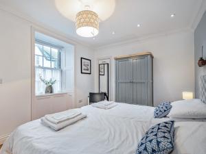 a bedroom with a white bed with towels on it at Killantrae Burn in Port William