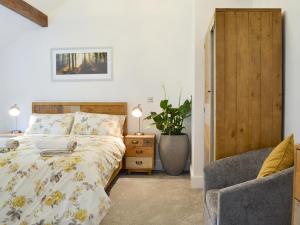 1 dormitorio con 1 cama y 1 silla en Woodhouse View, en Helsby