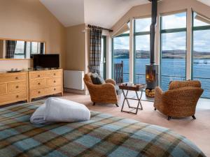 a bedroom with a bed and a fireplace and windows at Kyles View in Ollach