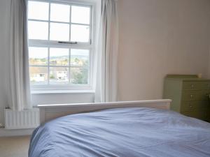 1 dormitorio con cama y ventana en Honeysuckle Cottage, en Watchet