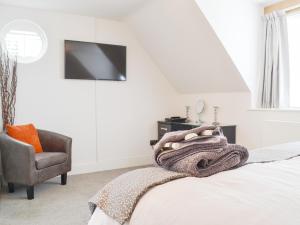 1 dormitorio con 1 cama y 1 silla en Willow Cottage, en Great Ryburgh
