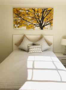 a bedroom with a bed with a painting on the wall at Stylish Getaway Stay In Beverly Hills in Los Angeles
