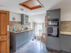 a kitchen with a sink and a stove top oven at The Cottage - Uk10514 in Carbis Bay