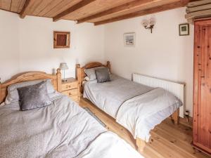 two beds in a bedroom with wooden floors at The Cottage - Uk10514 in Carbis Bay