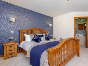 a bedroom with a bed with a blue accent wall at Sunnyside House in Duthil