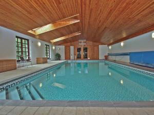 a large swimming pool with a wooden ceiling at Cothi Cottage in Llanfynydd