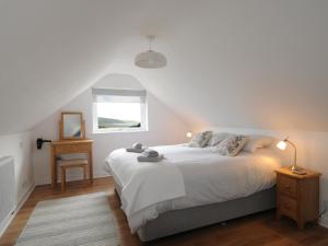 sypialnia z białym łóżkiem i oknem w obiekcie Bryn Derw w mieście Barmouth