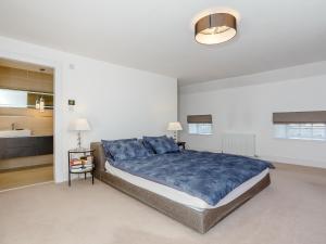 a bedroom with a large bed and a kitchen at Skene House Court in Dunecht