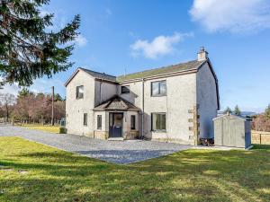 an old stone house with a large driveway at Knocknahighle in Cromdale