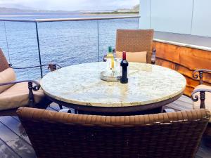 a table with two bottles of wine on a boat at Tidereach - Otters View in Connel