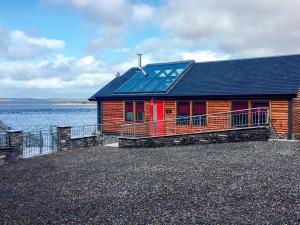 a house with a solar roof on the water at Tidereach - Otters View in Connel