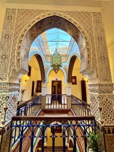 uma escadaria ornamentada num edifício com um lustre em Riad Al-Qurtubi em Tânger