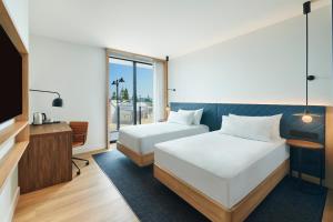 a hotel room with two beds and a tv at Hilton Garden Inn Busselton in Busselton