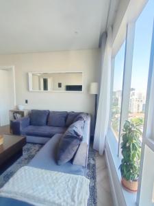 een woonkamer met een blauwe bank en een raam bij Spacious 2BR APT Near Sandton City -No Loadshedding in Johannesburg