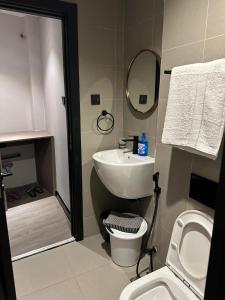 a bathroom with a sink and a toilet and a mirror at Lantana Cosy Home Studio Apartment in Nairobi