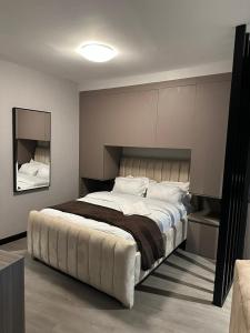 a bedroom with a large bed and a mirror at Lantana Cosy Home Studio Apartment in Nairobi