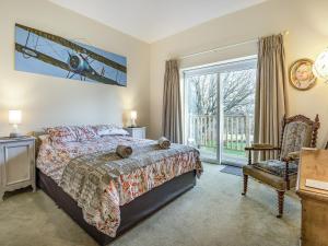 a bedroom with a bed and a chair and a window at Caldbec House in Battle