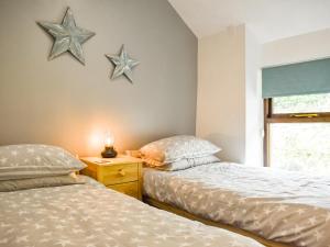 twee bedden in een kamer met sterren aan de muur bij Caer Elen in Dolwyddelan