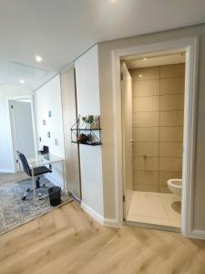 a bathroom with a shower and a desk and a toilet at Spacious 2BR APT Near Sandton City -No Loadshedding in Johannesburg