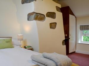 a bedroom with a bed with rocks on the wall at Penfold in Dockray