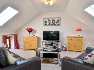 a living room with two couches and a tv at Higher Hopworthy Cottage-uk11436 in Pyworthy