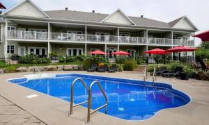 una piscina frente a un hotel con sombrillas rojas en LeChamplain #206 CITQ#248275 en Bromont