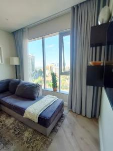 a bedroom with a bed and a large window at Spacious 2BR APT Near Sandton City -No Loadshedding in Johannesburg