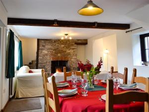 a dining room with a table and a fireplace at Dardy Cottage in Crickhowell