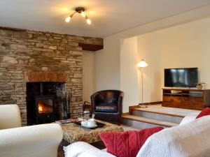 a living room with a fireplace and a tv at Dardy Cottage in Crickhowell