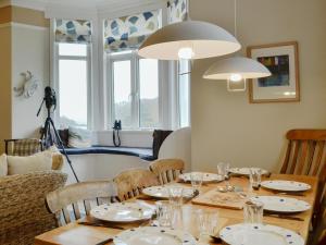 a dining room with a table with plates and glasses at Nevadd - Uk12303 in Menai Bridge