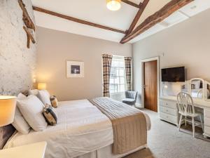 a bedroom with a large bed and a desk at The Scotch Arms Mews - Uk30910 in Brampton