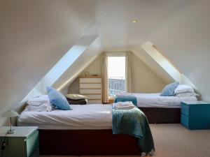 a attic bedroom with two beds and a window at Seaward in Portpatrick