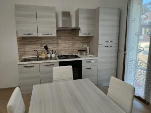 cocina con mesa, sillas y fregadero en Villa A&M 6, en Latina