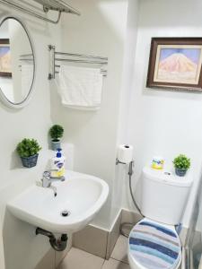 a bathroom with a sink and a toilet and a mirror at Family Staycation in Tagaytay in Tagaytay