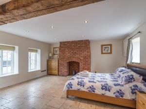 a bedroom with a bed and a brick fireplace at The Byre in Whitby