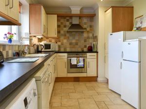 a kitchen with a white refrigerator and a stove at Bay View in Carlyon Bay