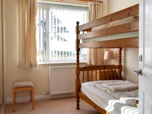 a bedroom with a bunk bed and a window at Bay View in Carlyon Bay