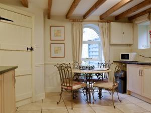 une cuisine avec une table et des chaises ainsi qu'une fenêtre dans l'établissement The Granary, à Dunvant