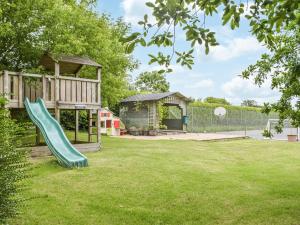 a playground with a slide in a yard at Rowan Cottage in Walton West