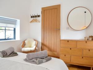 a bedroom with a bed with a mirror and a chair at The Hen House-uk12928 in St. Just