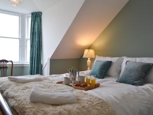 a large bed with a tray of food on it at Fircliff - The House On Bute in Port Bannatyne