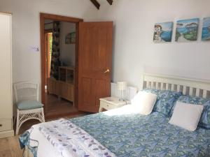a bedroom with a bed with a blue comforter at The Swallows in Appledore